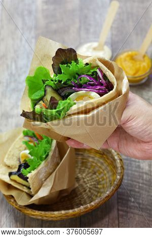 sabich: israeli pita sandwich with fried eggplant, hard boiled egg, israeli salad, amba and tahini souce
