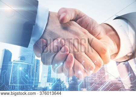 Handshake With Abstract Circuit Hologram And Skyscraper Background. Teamwork And Communication Conce