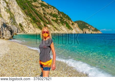 Lifestyle Woman With Orange Surgical Mask On Sansone Beach During Covid-19 Looking The Cliffs And Tu