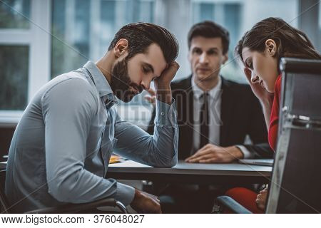 Two Employees Feeling Ashamed In Front Of Their Boss