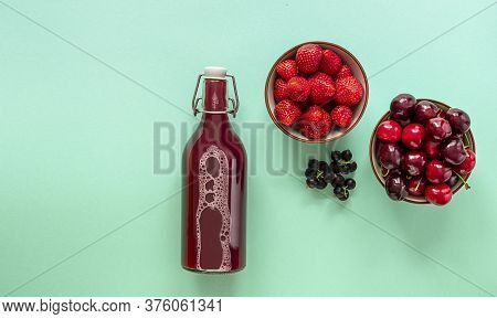 Fresh Berry Juice In A Glass Bottle With Ripe Strawberry, Cherry, And Black Currant. Top View, Copy 