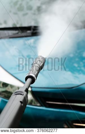 Car Wash At Home Alone. Car Wash High Pressure Close-up. A Man Washes A Green Car.