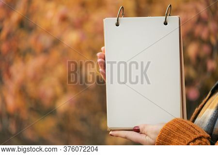 Autumn Mock Up.back To School. Blank White Notebook In The Girl Hands On Blurred Yellow Autumn Folia