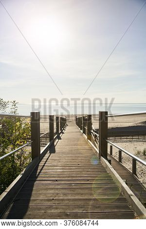 Wooden Boardwalk On Yantarniy Beach. Beach With A Blue Flag. Kaliningrad Region