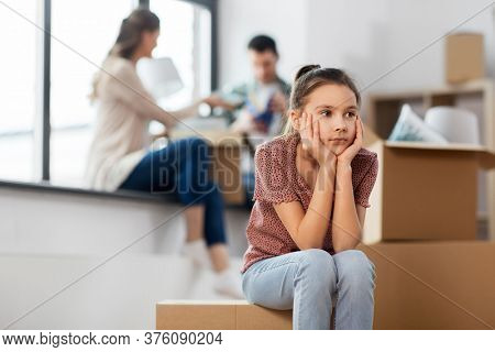 mortgage, family and real estate concept - sad girl moving to new home with mother and father packing things