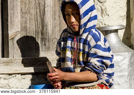 Jhong, Nepal - November 8, 2015: Nepali Boy Cutting Potatoes Near His House.