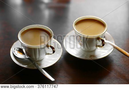 Two Tiny Coffee Cup With Hot Milk Coffee And Teaspoons