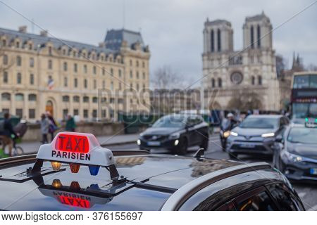PARIS, FRANCE - DECEMBER 23, 2019: Paris Taxi sing on the roof of a transportation car in French Captial.