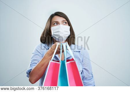 Attractive woman wearing protective mask isolated over white background