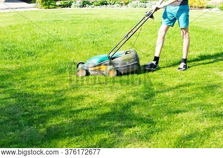 Young Man Mows The Lawn. High Quality Photo