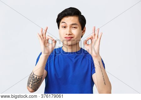 Lifestyle, People Emotions And Beauty Concept. Satisfied And Totally Pleased Asian Man Showing Okay 