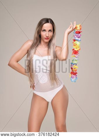 Beautiful Slim And Fit Girl With Long Blond Hair In Whiteswimsuit. Glowing Skin