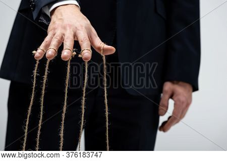 Partial View Of Puppeteer In Suit With Strings On Fingers Isolated On Grey