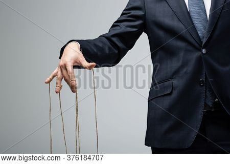 Partial View Of Puppeteer In Suit With Strings On Fingers Isolated On Grey