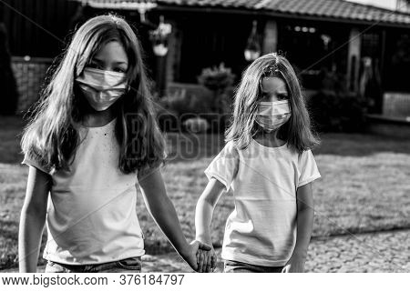 Girls Play In Medical Masks. Children Walk Outside In Times Coronavirus.