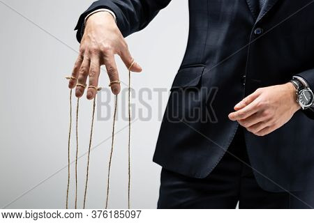 Partial View Of Puppeteer In Suit With Strings On Fingers Isolated On Grey
