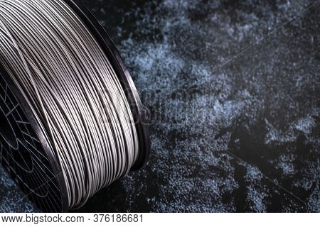 A Coil Of Filament For 3d Printing. Bright Thermoplastic Of Grey Color. Reel Vertical View. Coil On 