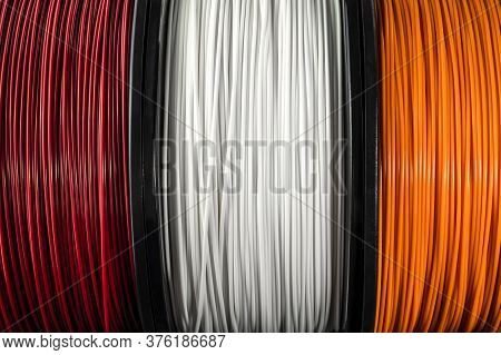 Three Coils Of Filament For 3d Printing. Bright Thermoplastic Of Red, White Smd Orange Colors. Reels