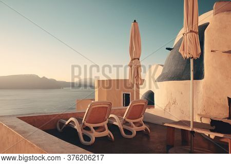 Leisure life settings with umberlla and chair in Santorini, Greece.