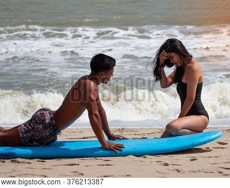 Blur Motion Of Young Handsome Man Teaching Beauty Lady For Basic Patter Of Surfing,on The Beach