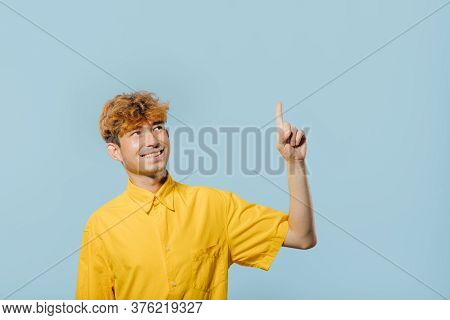 Cheerful Boy In Yellow Shirt Pointing Up Direction On Blue Background, Teenager Cu Coafura La Moda, 