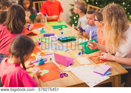 Teacher With Her Children While Christmas Cards Workshop