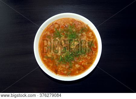 Kharcho Soup In A White Bowl On Dark Wooden Background. Top View. Famous Traditional Georgian Kharch
