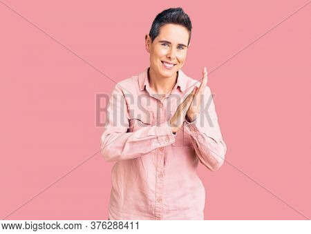 Young woman with short hair wearing casual clothes clapping and applauding happy and joyful, smiling proud hands together 