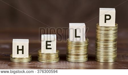 Coronavirus Financial Stimulus, Aid Package Concept, Gold Money Coins With Help Word On Wooden Cubes