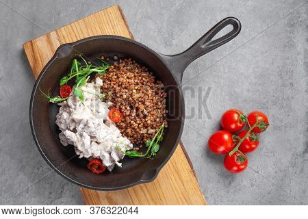 Beef Stroganoff In Cream And Buckwheat And Cherry Tomatoes In Pan