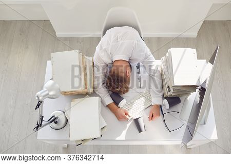 Tired Busy Businessman Sleeping At A Table With A Computer.