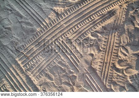 Tracks In Sand. Part Of Prints And Tracks Of Tire, Foot, Feet, Sun Sea Slippers In Beach Sand. Textu