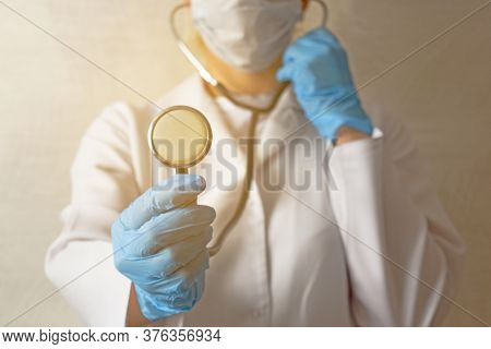 Stethoscope In The Hands Of A Doctor In Blue Gloves On A White Background