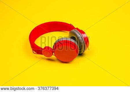 Red Headphones On Yellow Background. Music Concept