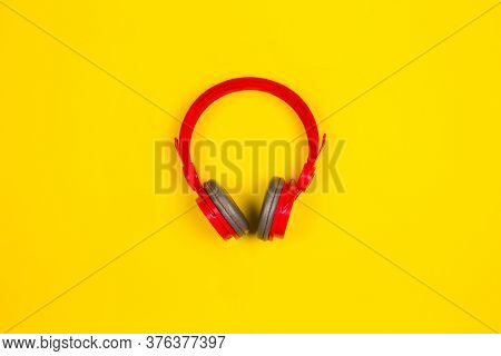 Red Headphones On Yellow Background. Music Concept