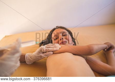 The Child Is Given An Injection, Vaccination, Doctor Makes An Injection With A Syringe To The Boy, T