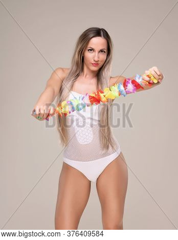 Beautiful Slim And Fit Girl With Long Blond Hair In Whiteswimsuit. Glowing Skin