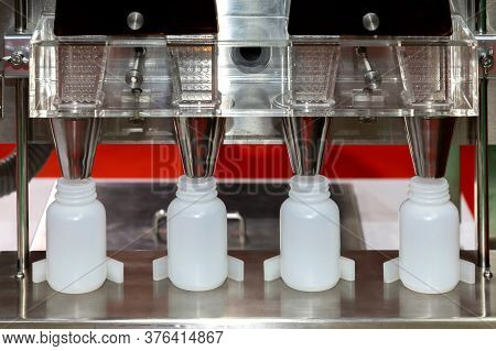 White Plastic Bottles On The Production Line Of The Conveyor At Filling Machine In The Factory. Madi