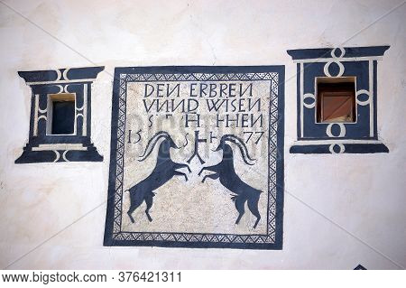 Guarda, Switzerland - Aug 14, 2009: Two Small Windows With Frescoes On A White Wall In The Ancient V