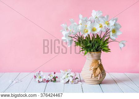 Bouquet Of White Wildflowers In A Vase On A Pink Background. Anemone Sylvestris