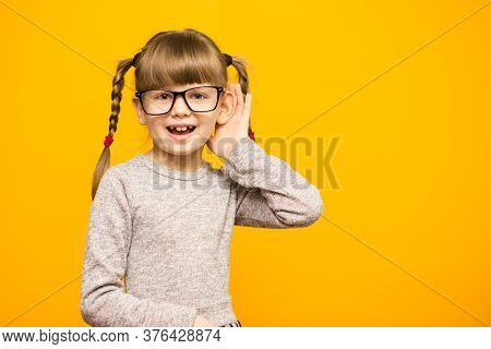 Little Child Girl Journalist In Glasses With Surprised Euphoria Face And Funny Pigtails Listening To