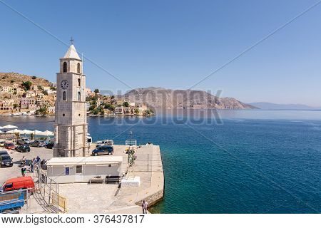 Symi, Greece - May 15, 2018: Clock Tower Symi And Sea Bay On Symi Island, Greece