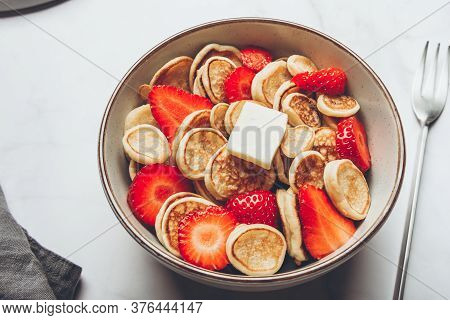 Trendy Home Breakfast With Tiny Cereal Pancakes With Piece Of Butter And Fresh Strawberries In The B