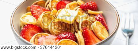 Trendy Home Breakfast With Tiny Cereal Pancakes With Piece Of Butter And Fresh Strawberries In The B