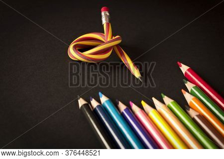 Flexible Pencil And A Set Of Colored Pencils On A Dark Background. Selective Focus