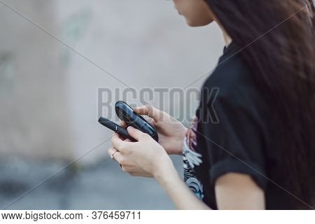 A Young Woman Outdoor Holds Iqos In A Hand. Heating Tobacco System Iqos, Iqos Tobacco Product Techno