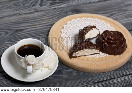 A Cup Of Black Coffee On A Saucer. Nearby Zephyr In Chocolate. Zephyr In The Form Of A Rose. One Zep