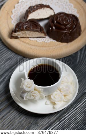 A Cup Of Black Coffee On A Saucer. Nearby Zephyr In Chocolate. Zephyr In The Form Of A Rose. One Zep