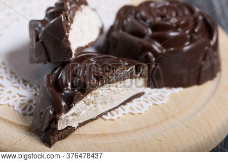 A Chocolate Marshmallow Made In The Shape Of A Rose Lies On A White Napkin. One Marshmallow Is Cut I