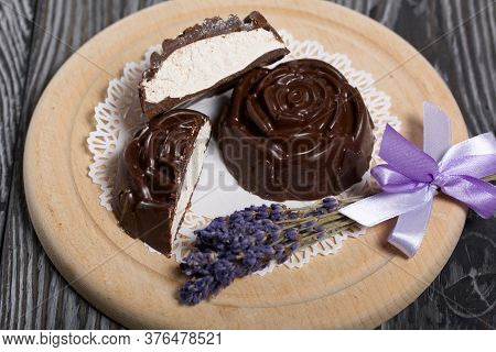 A Chocolate Zephyr Made In The Shape Of A Rose Lies On A White Napkin. One Zephyr Is Cut In Half, A